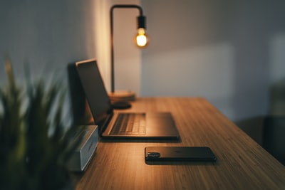 棕色木桌上的黑色笔记本电脑